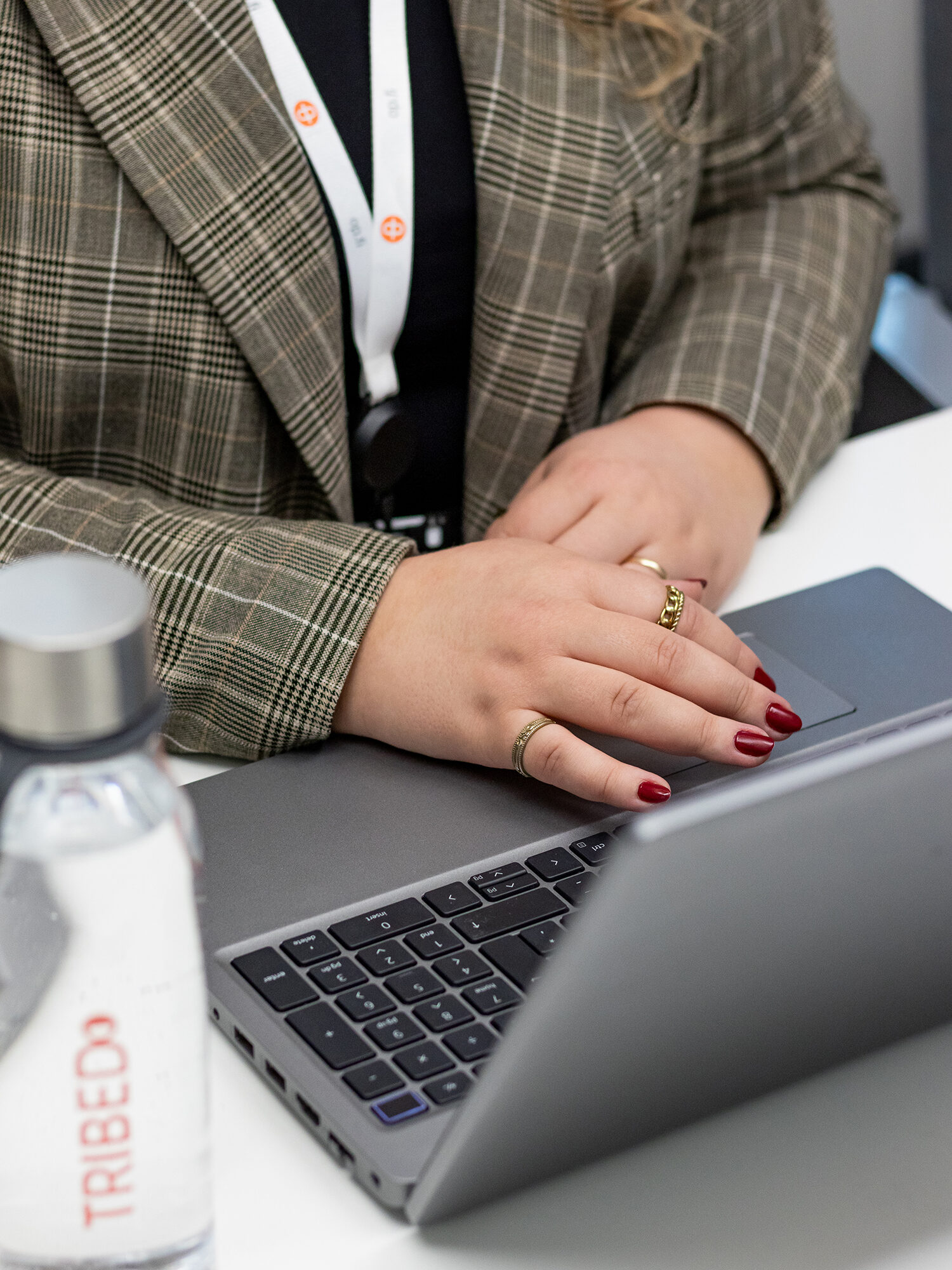 Lähikuva henkilön käsistä ja tietokoneesta. 