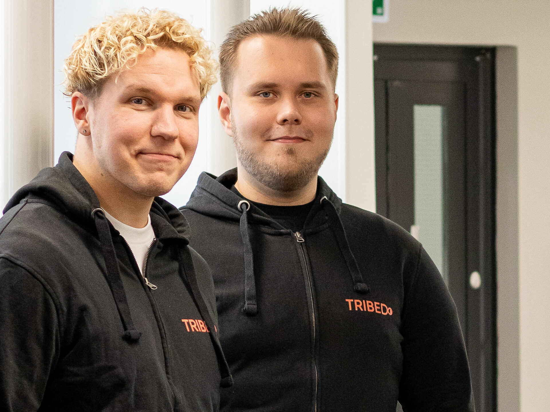 Kaksi ihmistä poseeraa ja katsoo lähikuvassa hymyillen kameraan