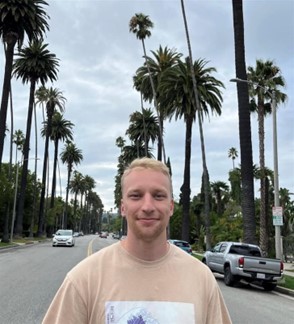 Veikko keskellä kuvaa. Taustalla palmupuita ja autoja tiellä.