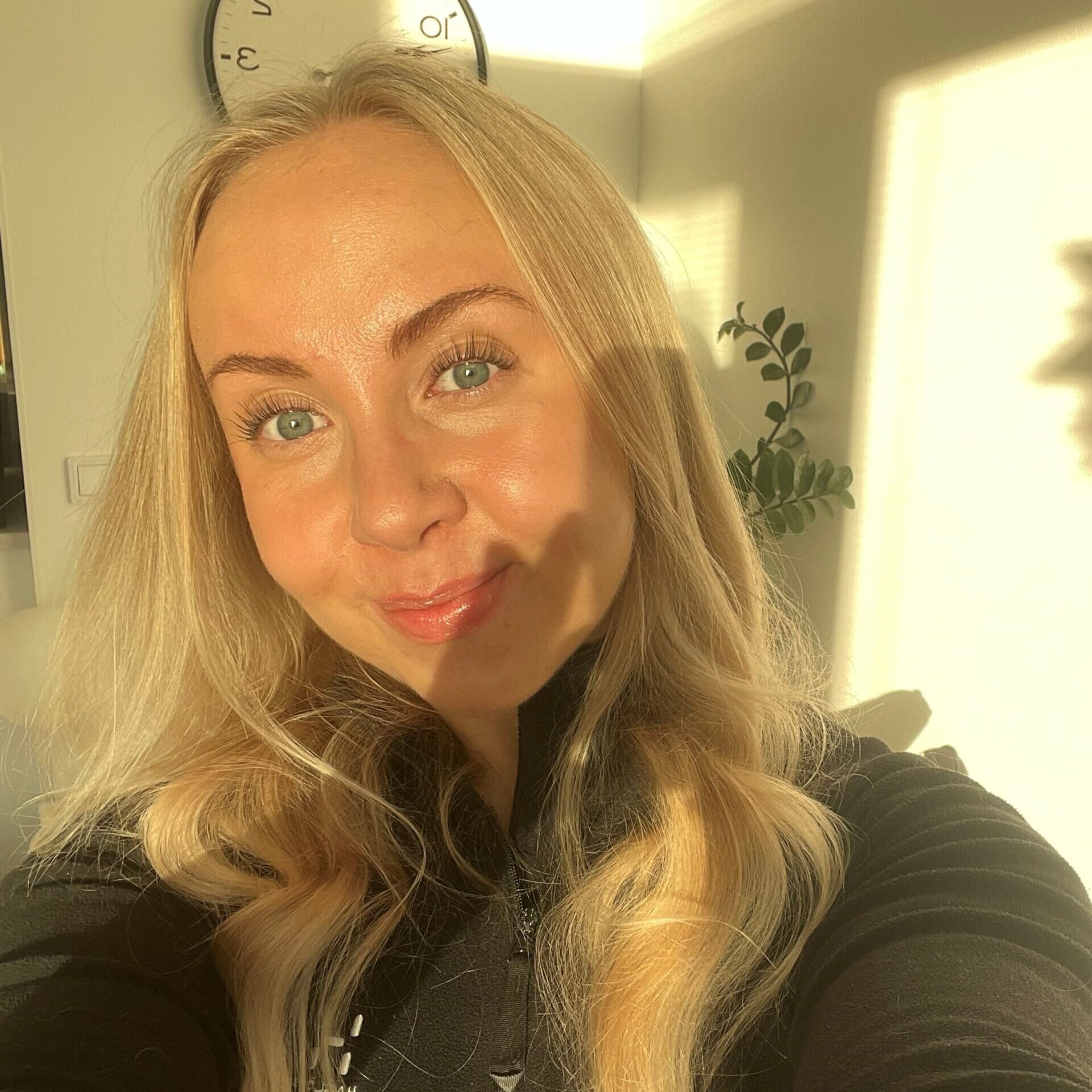 Kasvovokuva Vuoden tribedolainen 2025 Lotasta. Vaaleat pitkät hiukset laineilla, päällä musta paita ja aurinko paistaa kasvoille.